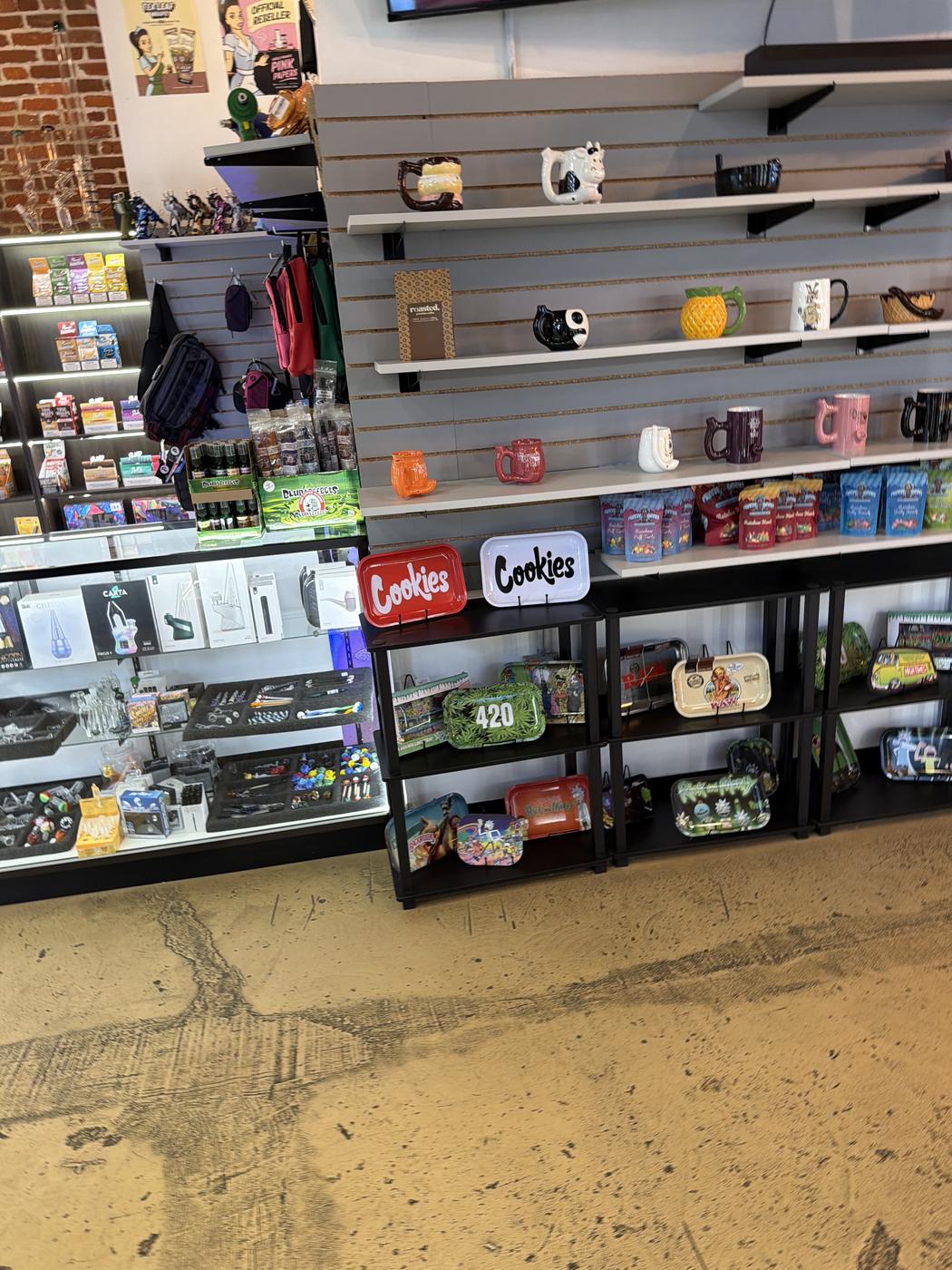 Glass display cases of pipes and accessories beside shelves of rolling trays.