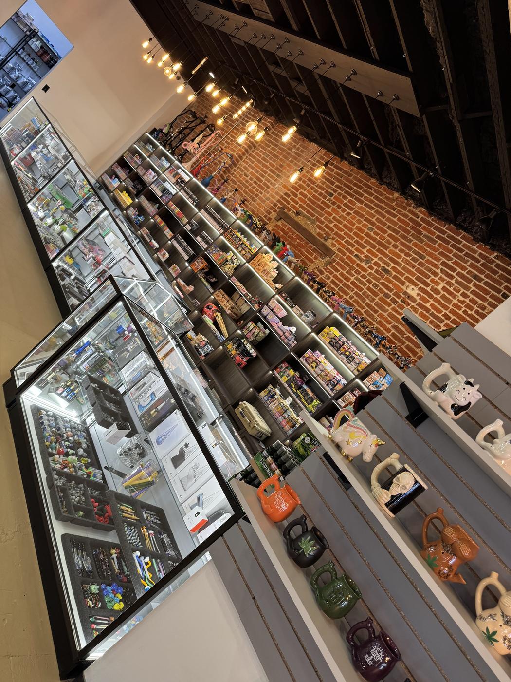 The retail floor, lit cases along one side and exposed brick above.